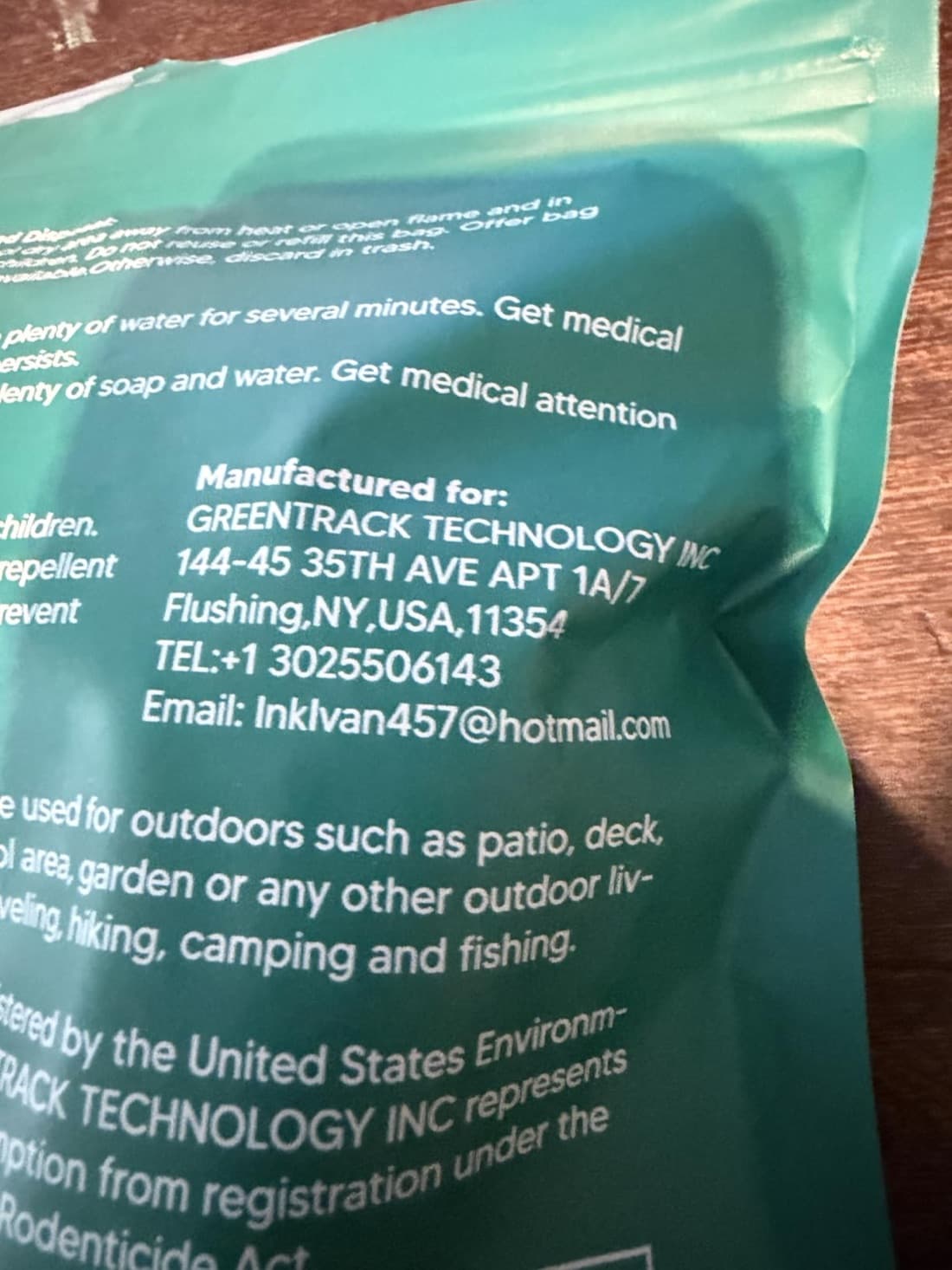 Back of a mosquito repellent balls package reading Manufactured for GREENTRACK TECHNOLOGY INC at a Flushing New York apartment address with a Hotmail email